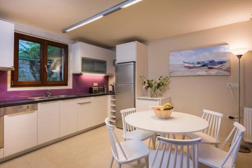 a kitchen with a white table and a table and chairs at Spilia Village Hotel & Villas in Spiliá