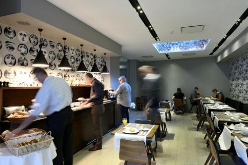 a group of people preparing food in a restaurant at Square Hotel in Kortrijk