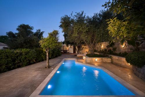 a swimming pool in a backyard at night at Spilia Village Hotel & Villas in Spiliá