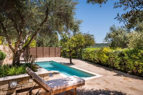 a swimming pool in a yard with a bench at Spilia Village Hotel & Villas in Spiliá