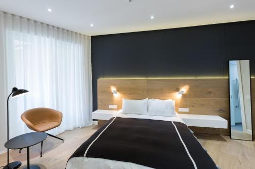 1 dormitorio con 1 cama grande y 1 silla en 005 Marina Apartment en Ciudad del Cabo