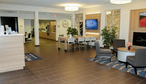a waiting room with tables and chairs in a building at Microtel Inn & Suites by Wyndham - Penn Yan in Penn Yan