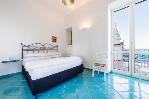 um quarto com uma cama e uma grande janela em La Luella em Sorrento