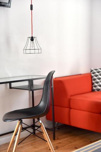 a red couch and a glass table and a red chair at Hydra Icons in Hydra