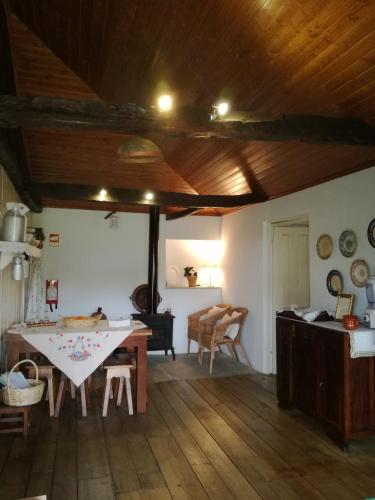 a kitchen with a table and a dining room at O Ze Ja Dormiu Aqui in Celeirós