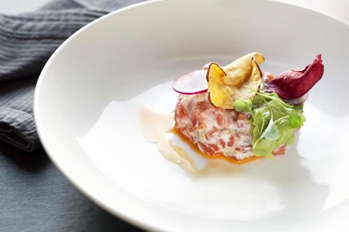 a white plate with a dish of food on it at Fairmont Le Chateau Frontenac in Quebec City