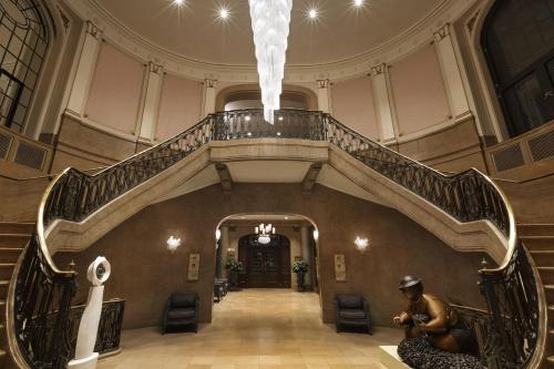 a spiral staircase in a building with a man sitting on the floor at Fairmont Le Chateau Frontenac in Quebec City
