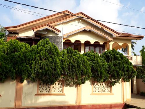 a house with trees in front of it at Brinthavanam Days Inn in Jaffna