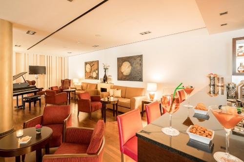 a living room with a table and chairs and a piano at Hotel Rose in Bretzfeld