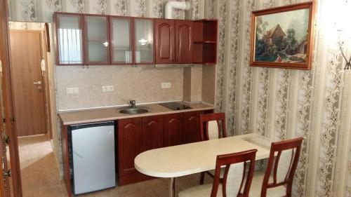 a kitchen with a sink and a table with chairs at Private Studio 1st line in Pomorie