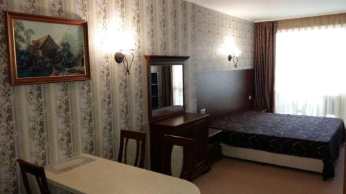 Cette chambre comprend un lit, une table et un miroir. dans l'établissement Private Studio 1st line, à Pomorie