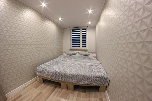 małą sypialnię z łóżkiem w ścianie w obiekcie Family Apartments w mieście Racibórz