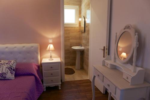 sypialnia z łóżkiem, umywalką i lustrem w obiekcie Villa Despina Benitses w mieście Benitses