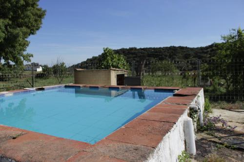 a swimming pool with a brick retaining wall at Casa Rural El Tejar in Higuera de la Sierra