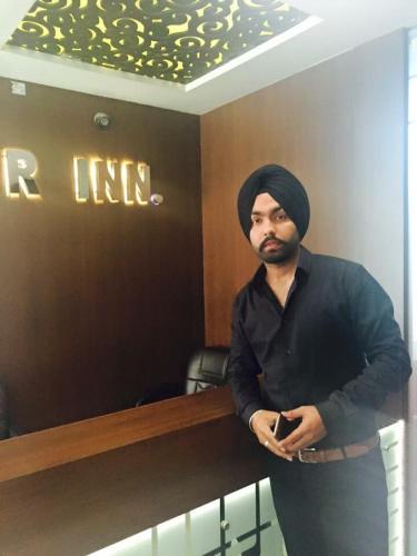 a man standing next to a counter in a room at Hotel Star Inn in Gangānagar