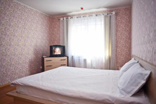 1 dormitorio con cama, ventana y TV en Kiev Sophii Rusovoi Apartment, en Kiev