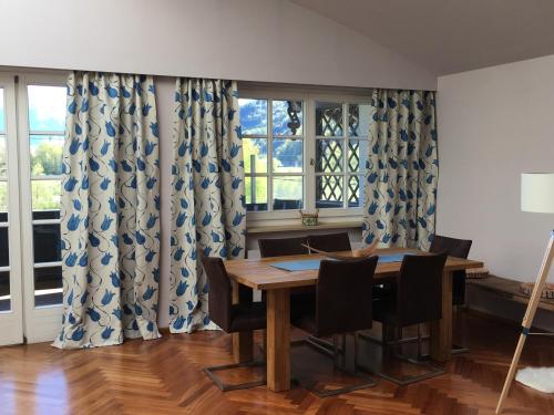 a dining room with a table and chairs and windows at Ferienwohnung Hochkönig im Barbarahof in Bischofshofen