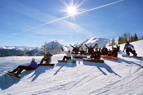 a group of people sitting in the snow on snowboards at Sporthotel Radstadt in Radstadt