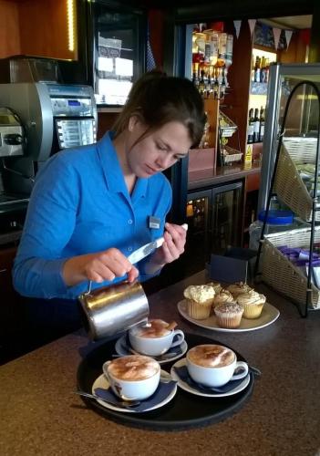 a woman is making cupcakes in a kitchen at Heights Hotel in Portland