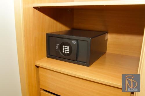 a microwave oven sitting inside of a cabinet at Rocha Prestige - Guest House and Suites in Portimão