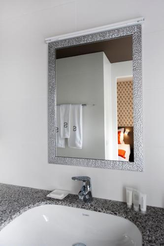 a bathroom with a sink and a mirror at Square Hotel in Kortrijk