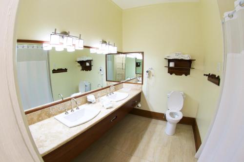 a bathroom with two sinks and a toilet at The Great House Inn in Belize City