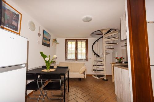 a kitchen and living room with a table and a spiral staircase at Il Tiglio in Moneglia