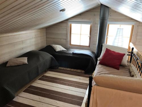Habitación pequeña con 2 camas y sofá en Rukan Sarastus, en Ruka