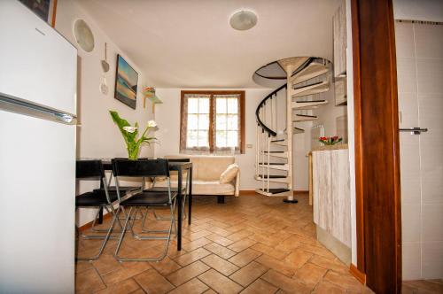 a living room with a table and a spiral staircase at Il Tiglio in Moneglia