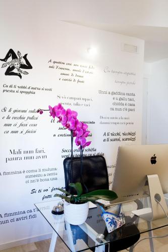 a table with a vase of flowers on a wall at B&B Porta di Ponte in Agrigento