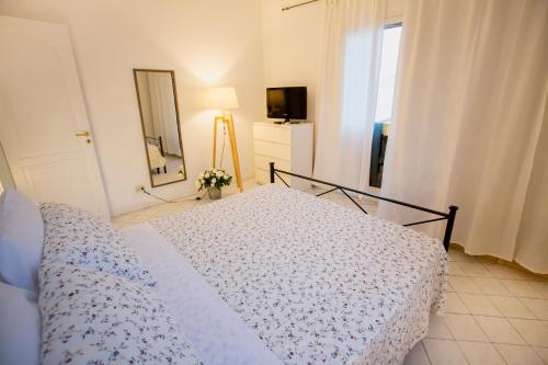 a bedroom with a bed and a mirror and a window at Azzurro B&B in Cefalù