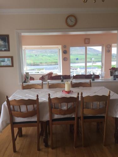 a dining room with a table and chairs and a clock at Iveragh Heights in Cahersiveen