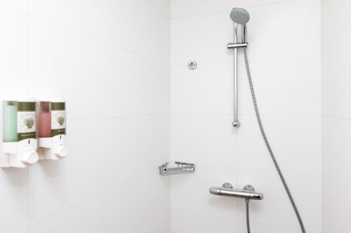 W łazience znajduje się prysznic z głowicą prysznicową. w obiekcie MVC Eagle Beach w Palm Beach