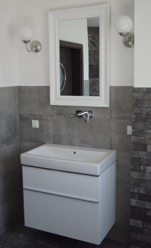 a bathroom with a white sink and a mirror at Ferienhaus Hirtenstaller Düne in Büsum