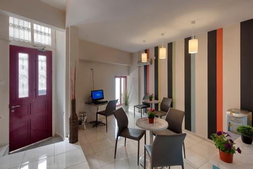een lobby met een rode deur en een tafel en stoelen bij Paradise in Ermoupoli