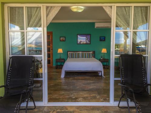 a bedroom with a bed and two chairs at Sava Salinas in Las Salinas