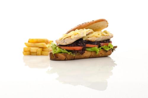 a sandwich and french fries on a white background at Hotel Hacienda Abraspungo in Riobamba