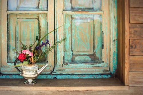 a vase with flowers in it sitting in front of a door at Alquimista Montevideo in Montevideo