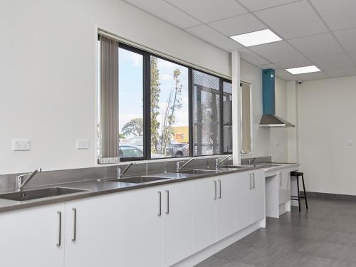 una cocina con lavabos y ventanas en una habitación en Three Palms Lodge, en Auckland