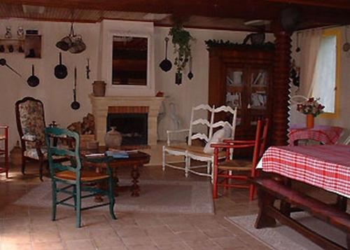 a living room with chairs and a bed and a fireplace at Ferme les Rousseaux in La Belliole