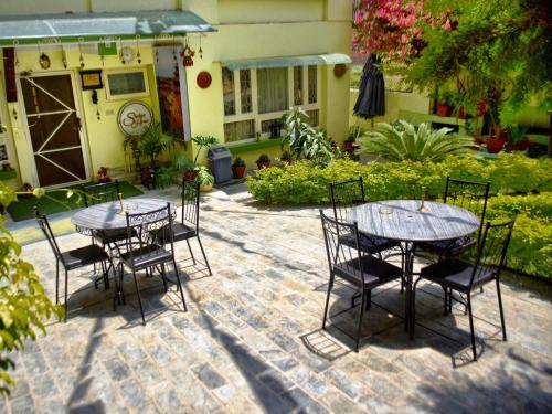 a patio with two tables and chairs on a brick patio at Shakya House in Pātan