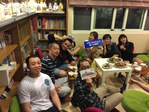 a group of people sitting in a library eating food at Doll House Lodge in Hengchun