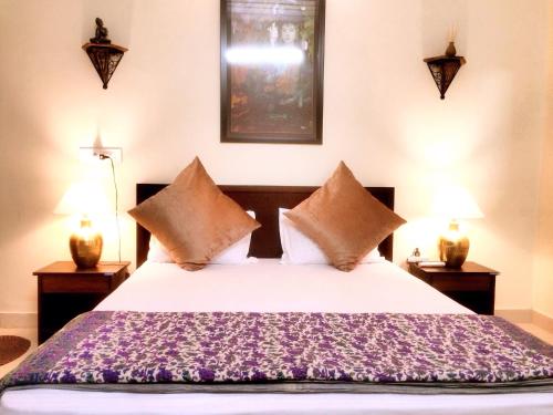 a bedroom with a large bed with two lamps at The Buddhayan Villa in Jaipur