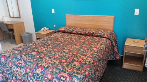 a bedroom with a bed with a colorful comforter at Economy Inn Motel in Sylmar