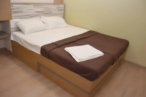 a bed with a brown blanket and white sheets at Central Inn, Kolhapur in Kolhapur