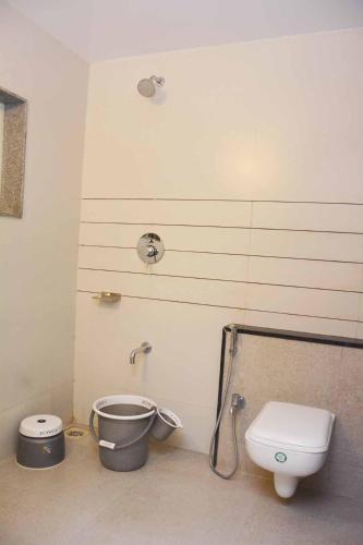a bathroom with a toilet and a bucket at Central Inn, Kolhapur in Kolhapur