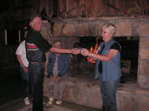 a man and a woman standing in front of a fireplace at Arrowmont Stables & Cabins in Cullowhee
