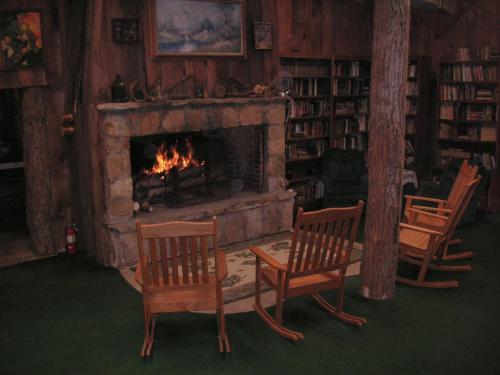 a living room with two chairs and a fireplace at Arrowmont Stables & Cabins in Cullowhee