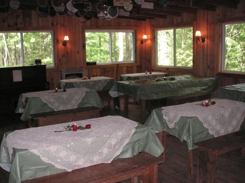 a dining room with green tables and windows at Arrowmont Stables & Cabins in Cullowhee