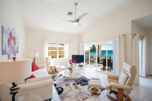 a living room with white furniture and a view of the ocean at Regal Beach Club in George Town